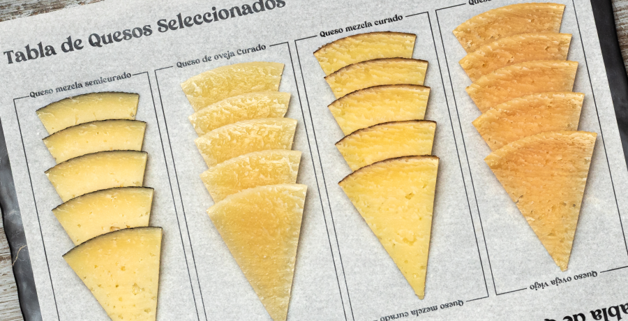 Tabla de quesos ibéricos con cuñas de diferentes curaciones (semicurado, curado y viejo) colocadas en abanico.