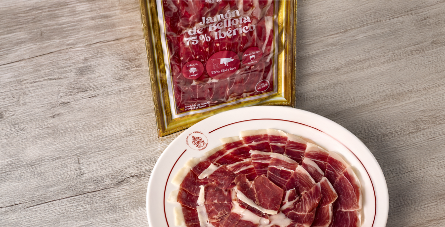Sobre de jamón ibérico loncheado junto a un plato de jamón servido en Museo del Jamón.